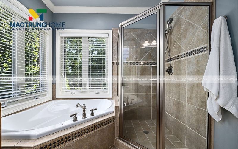 Nhà vệ sinh có tường gạch ốp và gạch lát sàn vân đá cùng màu