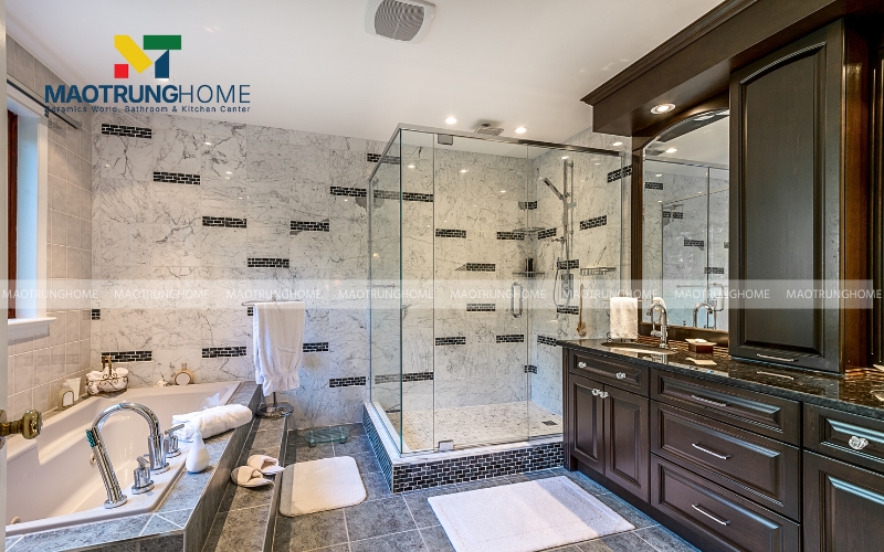 Tổng thể không gian nhà vệ sinh phong cách Indochine ấm cúng với sàn lát gạch bông và tủ lavabo gỗ tự nhiên