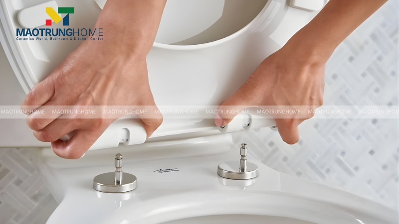 Đầu tiên, bạn cần tháo nắp bồn cầu cũ