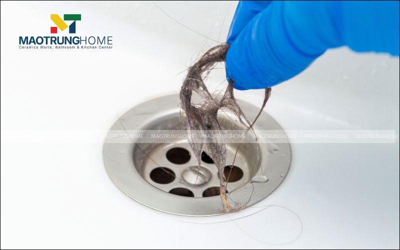 Gắp các búi tóc và cặn bẩn lớn để vệ sinh nắp bồn tắm
