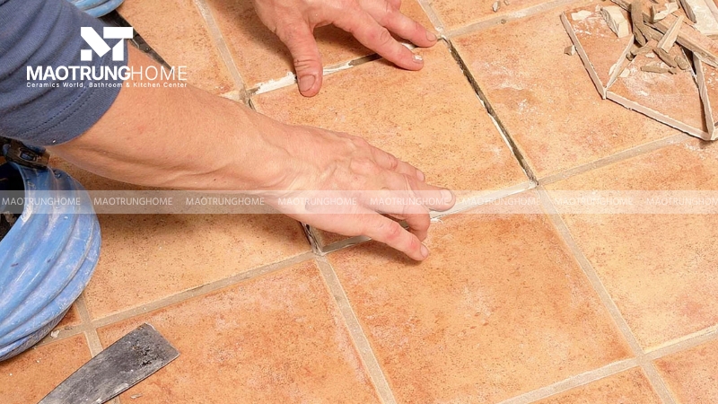Dùng máy mài cầm tay hoặc dao rọc ron chuyên dụng để loại bỏ lớp keo cũ xung quanh viên gạch