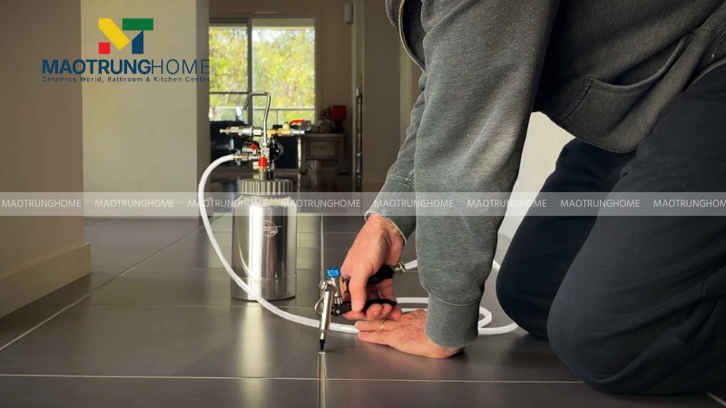 Dùng bơm áp lực để đưa keo epoxy vào bên dưới gạch lát nền