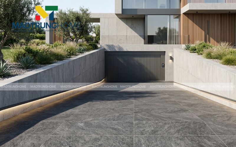 Gạch xương granite nhám sần giả đá khổ lớn mang lại diện mạo liền mạch, vững chãi và hiện đại cho lối vào hầm gara.