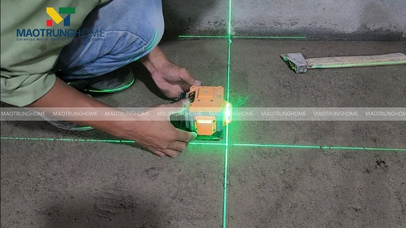 Người thợ sử dụng máy cân bằng laser để kiểm tra cao độ cốt nền