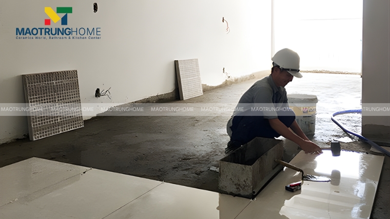 Người thợ dùng búa cao su gõ nhẹ vào gạch để ép không khí ra ngoài